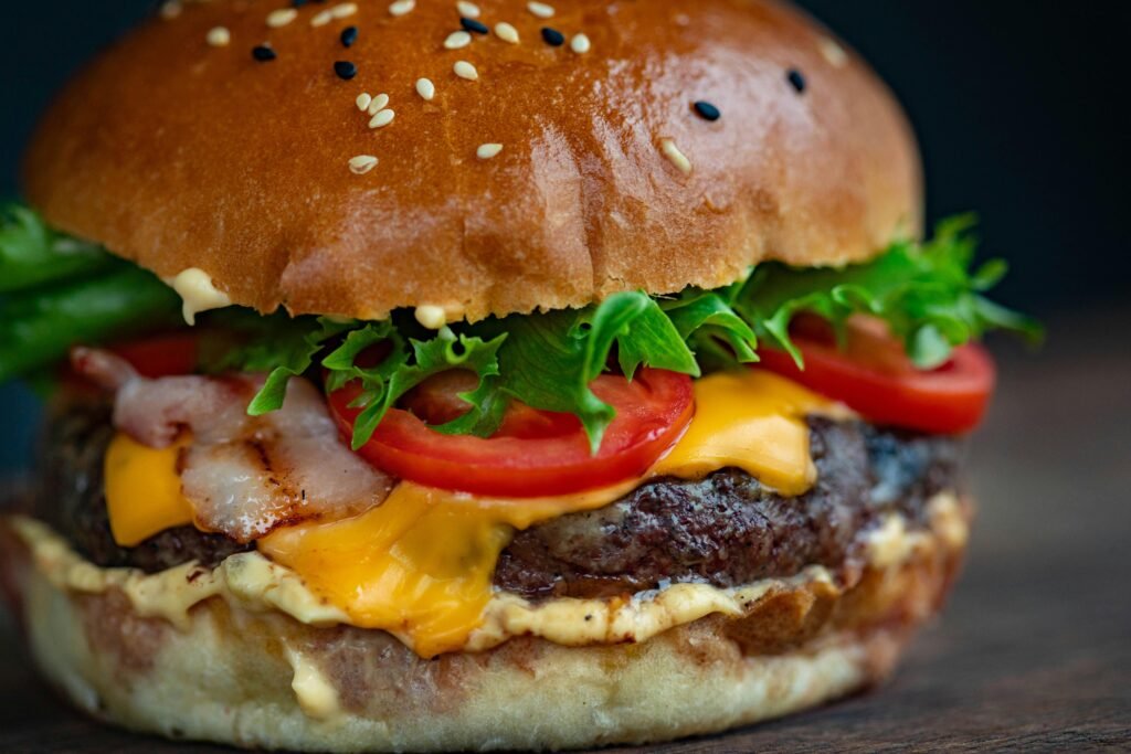 pexels-photo-1639557-1639557-1 Juicy cheeseburger with bacon, lettuce, tomato, and sesame seed bun.